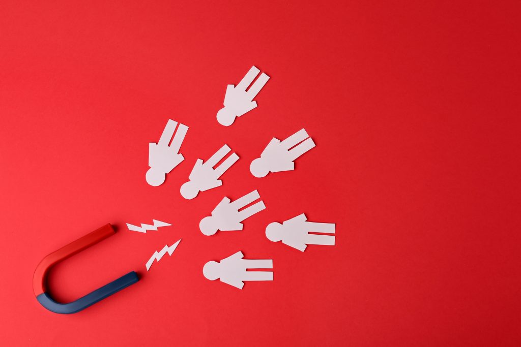 Magnet and paper people on red background